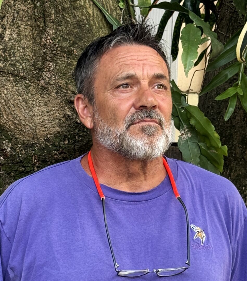 Bearded man in purple shirt looking upward